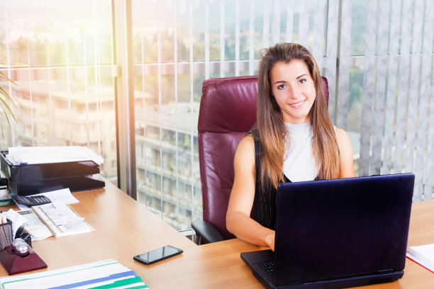 年轻漂亮的女士在办公室里用笔记本电脑工作图片下载