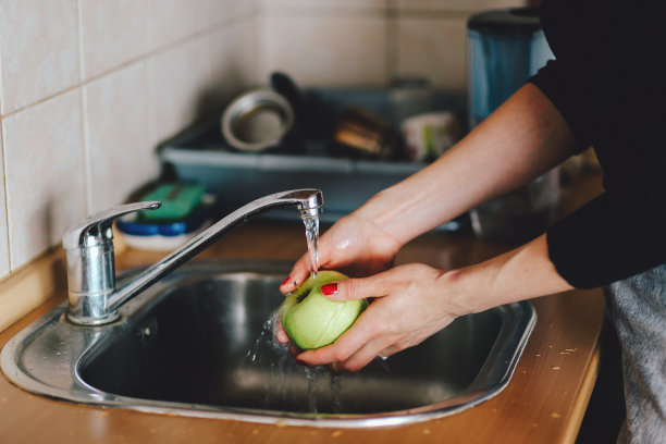 一个年轻女人在厨房里洗苹果素材图片