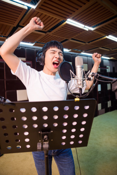 一个年轻的歌手在录音室录制一个轨道的特写图片下载