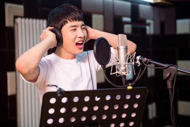 一个年轻的歌手在录音室录制一个轨道的特写图片下载