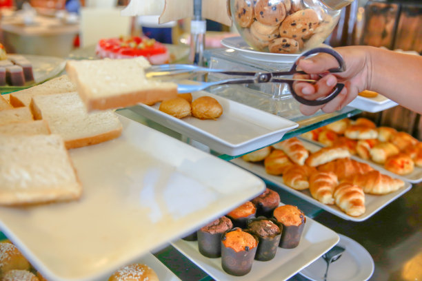 一个成年人在吃自助早餐时吃一片面包图片下载