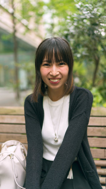 坐在长椅上微笑的年轻女子图片下载