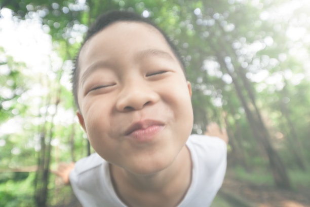 小男孩在森林里做鬼脸图片下载