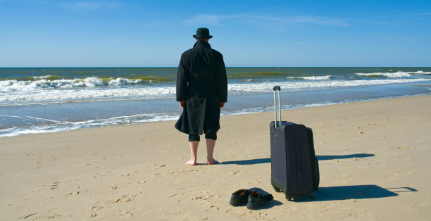 一名身穿黑色服装的游客来到海滩图片下载