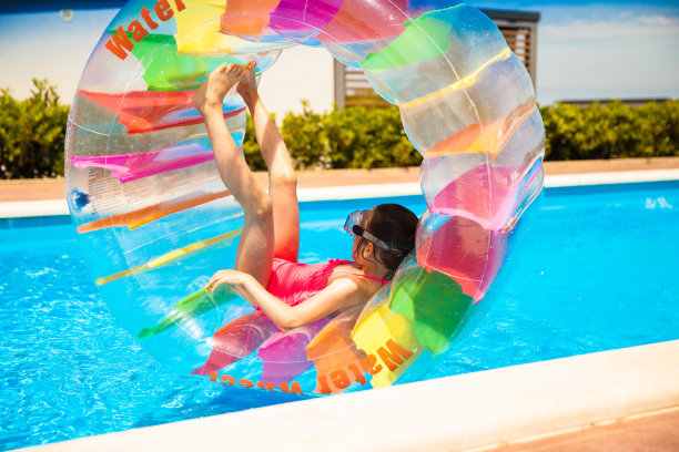 快乐的女孩在充气水轮内的游泳池里放松图片下载