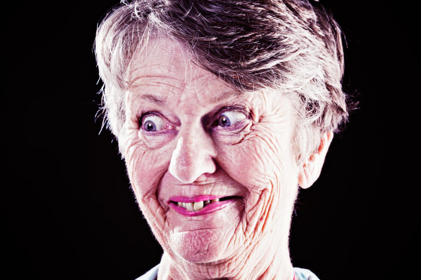疯狂的老妇人的肖像微笑着闪烁的眼睛图片下载