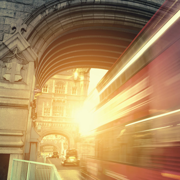 黄昏时分，伦敦塔桥上一辆双层巴士的灯光轨迹图片下载