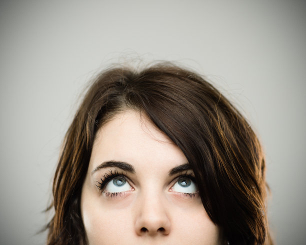 真正的年轻女子抬头看的特写图片下载