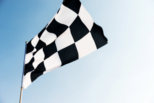 蓝天上飘扬着方格旗素材图片