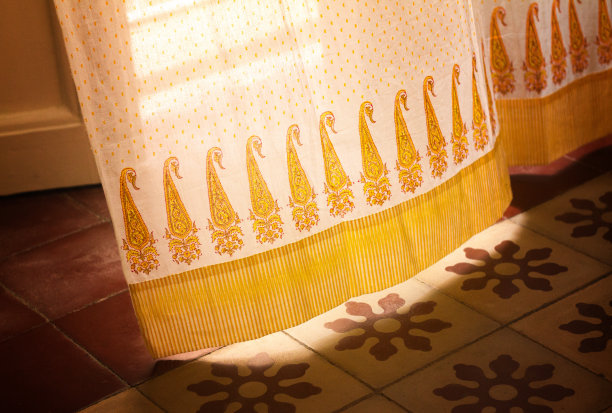 黄色窗帘在意大利瓷砖地板上吹来图片下载