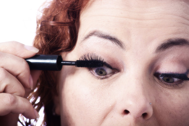 女人在化妆时把睫毛膏涂在睫毛上图片下载