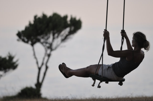 在木秋千上荡秋千的女人图片下载