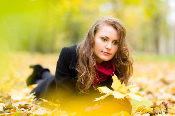 迷人的悲伤的女人与秋天的叶子图片下载