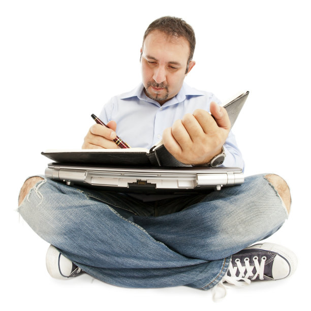 坐在地板上，拿着笔记本电脑、日程表等。图片下载