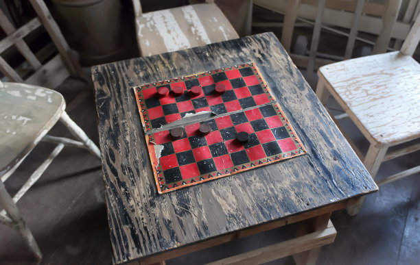 带桌子的房间，十九世纪八十年代的跳棋游戏。古董。图片下载