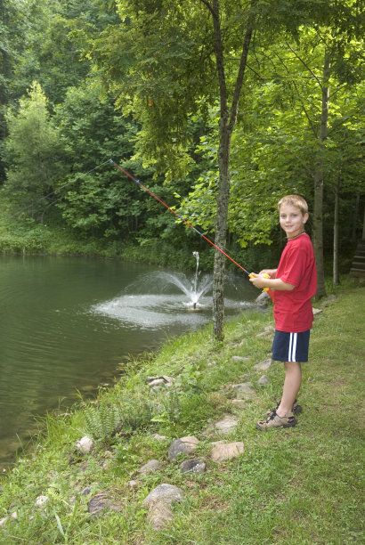 男孩站在池塘边钓鱼图片下载