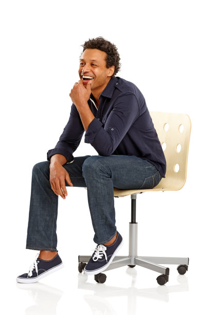 快乐的非洲人坐在椅子上看向别处图片下载