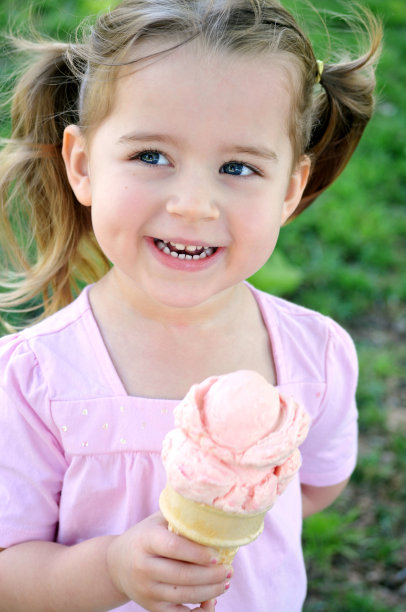 一个年轻的女孩在一个夏天在外面吃冰淇淋图片下载