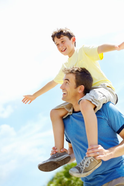 儿子在他父亲的肩膀上玩耍图片下载