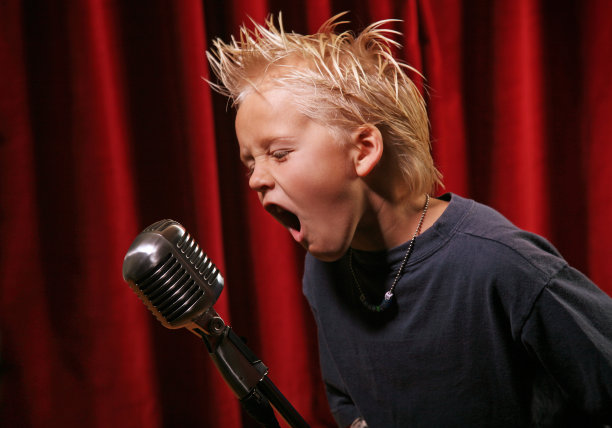 朋克小子在舞台上对着麦克风唱歌图片下载