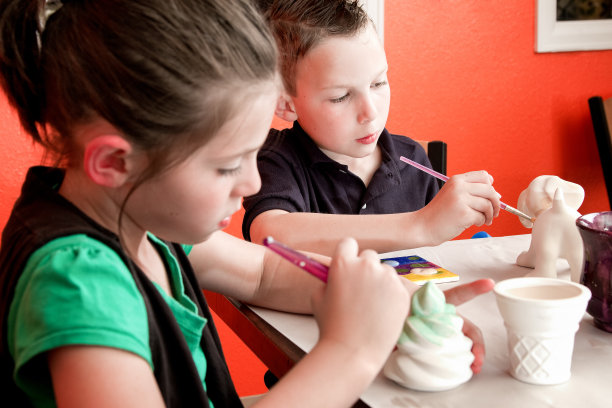 8岁白人女孩和男孩画陶器素材图片