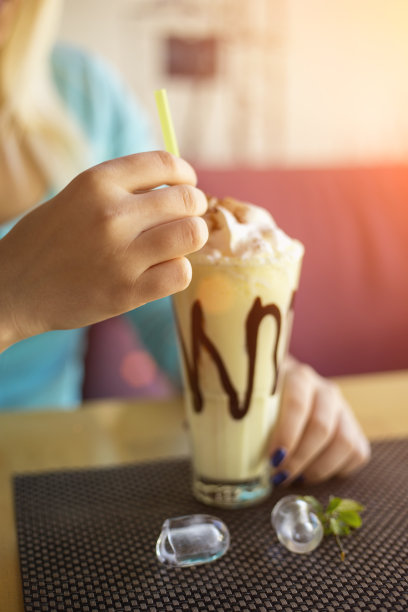 快乐的年轻女子喝着柠檬奶昔图片下载