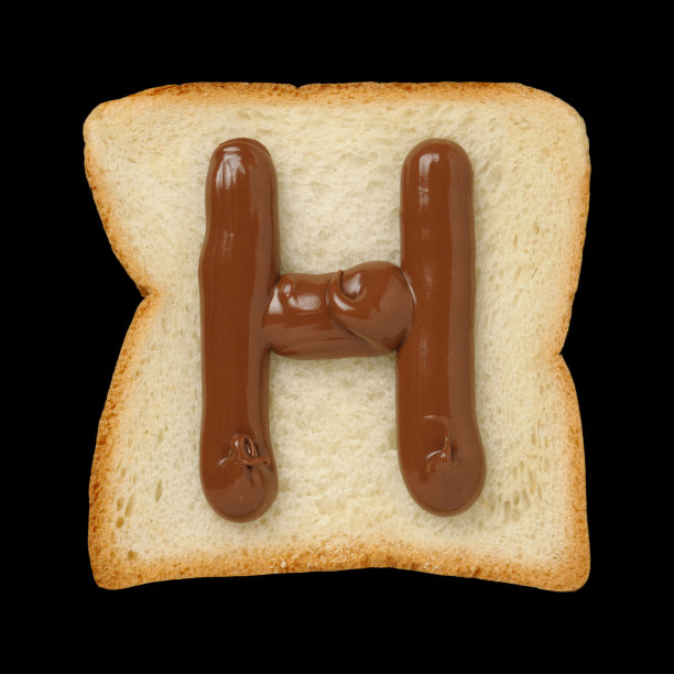 巧克力字母H在锡箔面包片，黑色背景图片下载