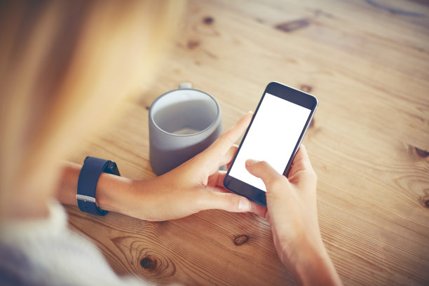 在餐桌上使用黑屏幕智能手机的女人图片下载