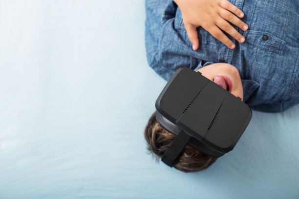 男孩戴着虚拟现实眼镜玩游戏图片下载