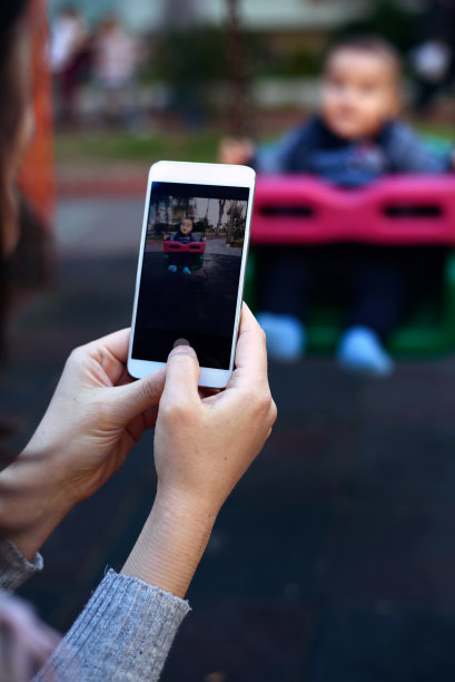 妈妈在操场秋千上拍婴儿的照片图片下载