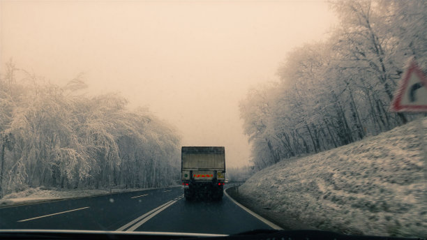 冬天卡车行驶在下雪的乡村道路上图片下载