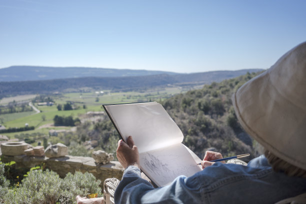 俯瞰田园山谷的女人在画画图片下载