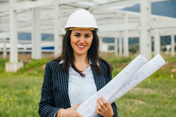 工地上女建筑师的肖像和蓝图图片下载