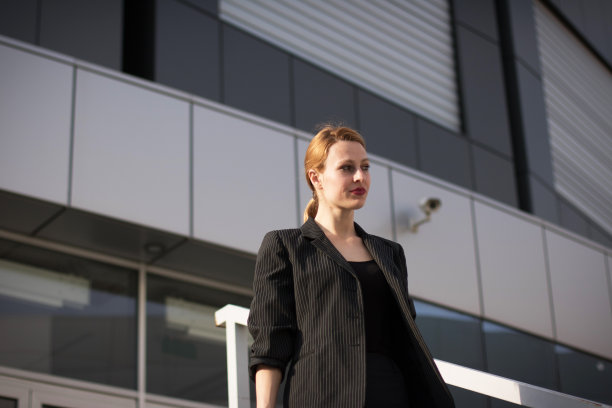 年轻漂亮的女商人站在办公室前面图片下载