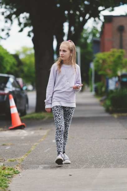 一个小女孩在街上边走边听手机图片下载