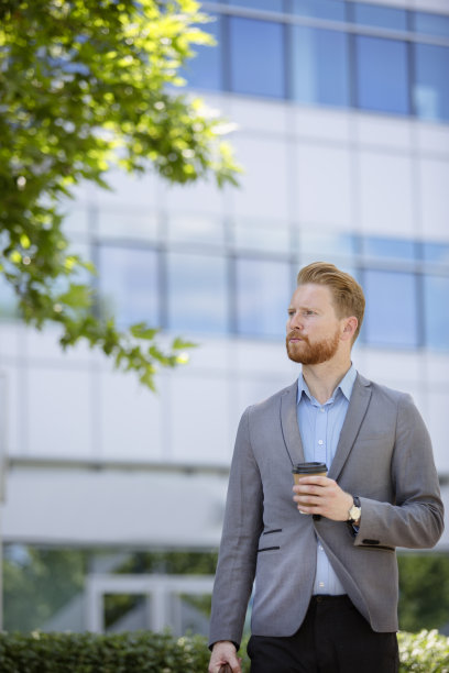 年轻的商人站在楼前图片下载