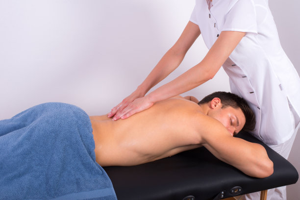 年轻英俊的肌肉男享受背部按摩图片下载