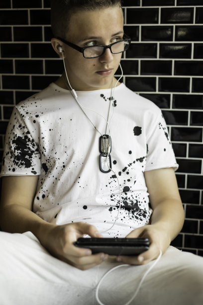 一个少年靠在砖墙上图片下载