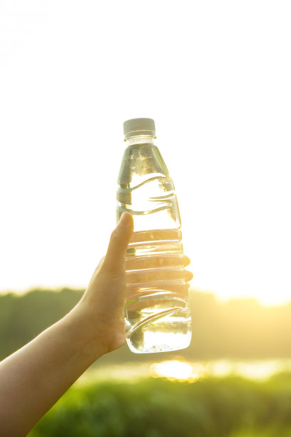 手拿一瓶水在公园里图片下载