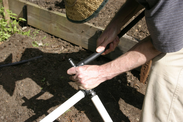 男子连接塑料管道花园灌溉图片下载