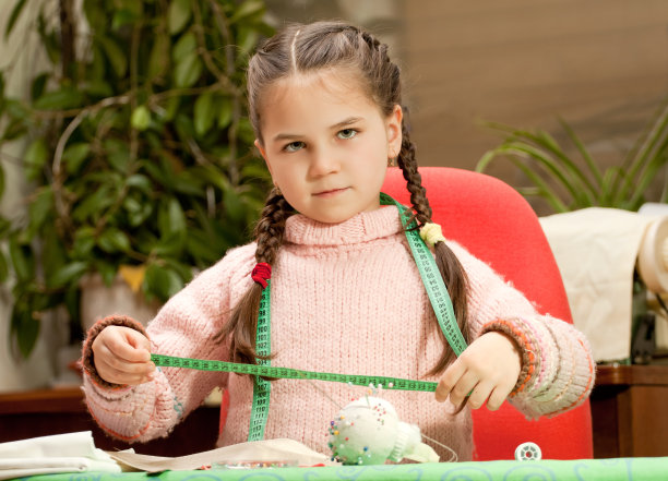 可爱的小女孩在学缝纫图片下载