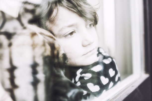 沉思的孩子和她的狗从窗户往外看图片下载