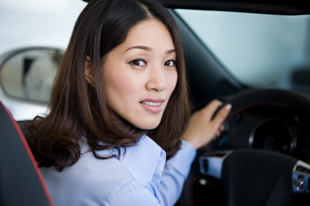 美丽的女商人开着车，看着镜头图片下载