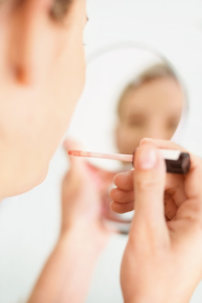 年轻的金发正在涂唇彩图片下载