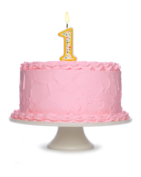 粉色糖霜生日蛋糕，上面点着1号蜡烛图片下载