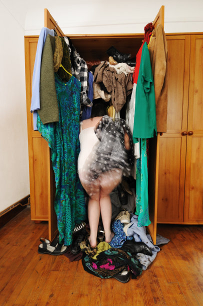 女人在不整洁的衣柜里寻找衣服图片下载