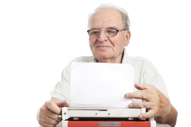 一位老人在打字机上写字。图片下载