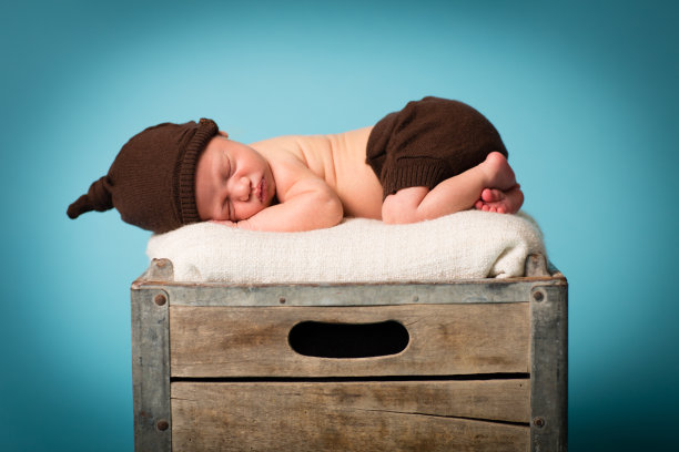 熟睡的新生儿躺在旧木箱上图片下载