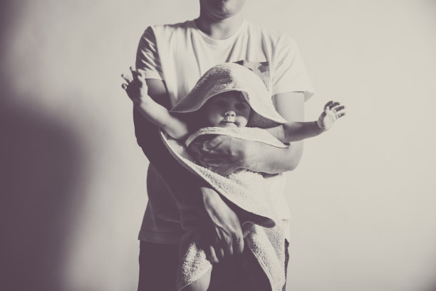 父亲抱着裹着毛巾的儿子图片下载