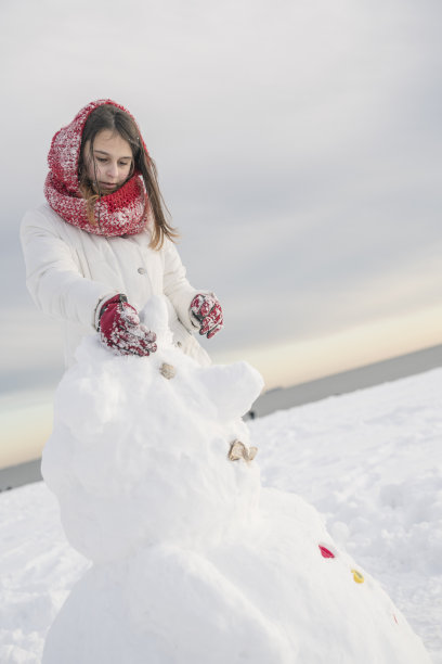 少女在海滩上堆雪人图片下载